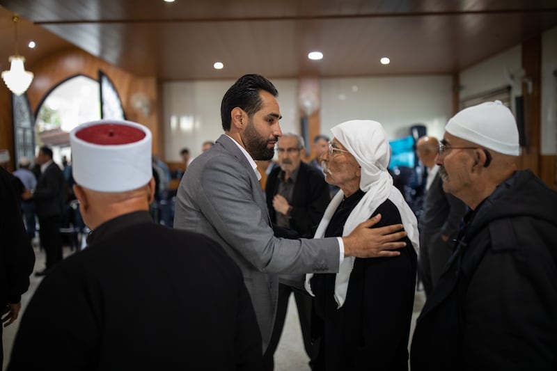 Druze opposition candidate Firas Hamdan greets members of the sect in a hall in the village of Kfeir in South Lebanon.  All Photos: Oliver Marsden for The National