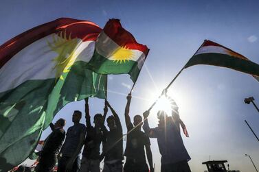 Iraqi Kurds wave flags during a demonstration outside the UN Office in Erbil, the capital of the Kurdish autonomous region. Safin Hamed / AFP