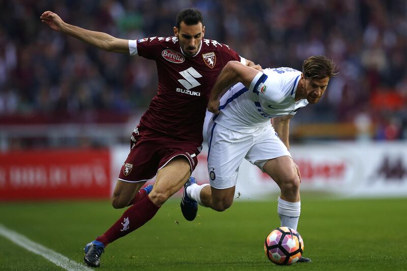 Torino's defender Davide Zappacosta (L) vies for the ball with Inter Milan's Argentinian defender Cristian Ansaldi during the Italian Serie A football match Torino versus Inter Milan on March 18, 2017 at the 'Grande Torino Stadium' in Turin. / AFP PHOTO / Marco BERTORELLO