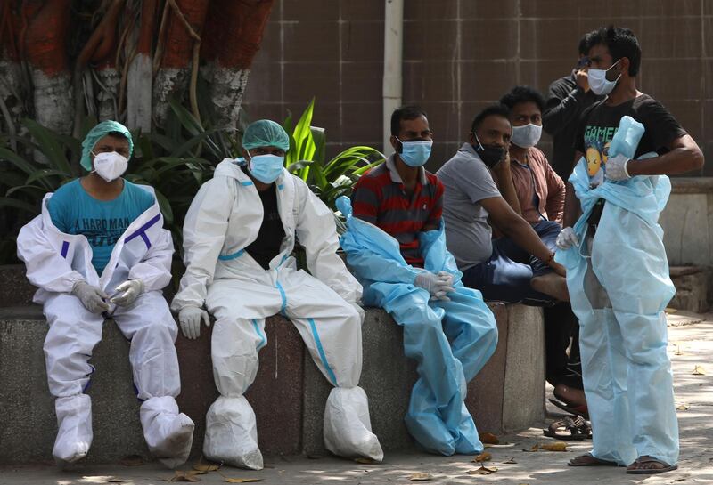 Workers take rest in between cremating Covid-19 victims in New Delhi, which has had an explosive surge in coronavirus cases. AP Photo
