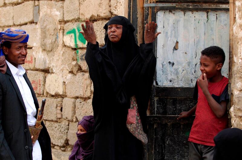 Members of Yemen's 'Muhamasheen' minority stand outside a rare brick dwelling in the slums of Sanaa. AFP