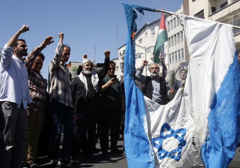 Iranians burn an Israeli flag during a rally marking Al Quds Day in Tehran on Friday. EPA