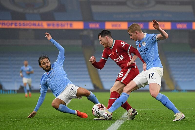 Liverpool's Scottish defender Andrew Robertson (C) gets tackled by Manchester City's Belgian midfielder Kevin De Bruyne (R) and Manchester City's Portuguese midfielder Bernardo Silva (L) during the English Premier League football match between Manchester City and Liverpool at the Etihad Stadium in Manchester, north west England, on November 8, 2020. RESTRICTED TO EDITORIAL USE. No use with unauthorized audio, video, data, fixture lists, club/league logos or 'live' services. Online in-match use limited to 120 images. An additional 40 images may be used in extra time. No video emulation. Social media in-match use limited to 120 images. An additional 40 images may be used in extra time. No use in betting publications, games or single club/league/player publications.
 / AFP / POOL / Shaun Botterill / RESTRICTED TO EDITORIAL USE. No use with unauthorized audio, video, data, fixture lists, club/league logos or 'live' services. Online in-match use limited to 120 images. An additional 40 images may be used in extra time. No video emulation. Social media in-match use limited to 120 images. An additional 40 images may be used in extra time. No use in betting publications, games or single club/league/player publications.
