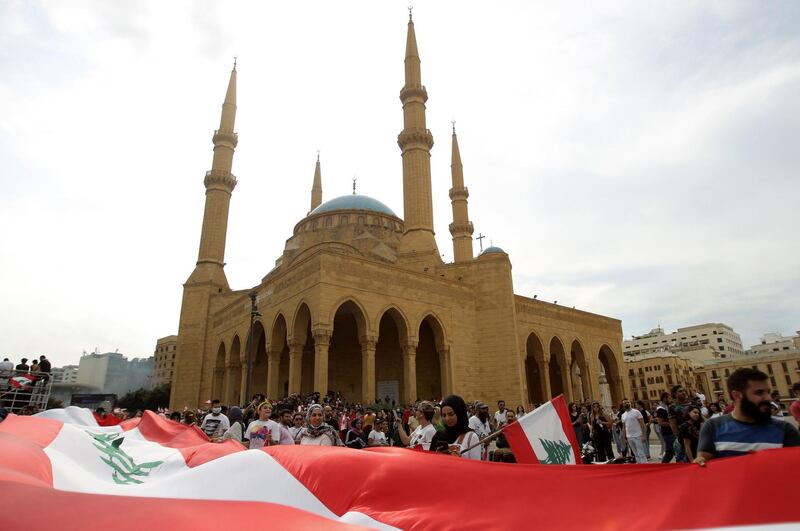 Lebanese demonstrators wave the national flag during a protest against dire economic conditions in downtown Beirut. AFP