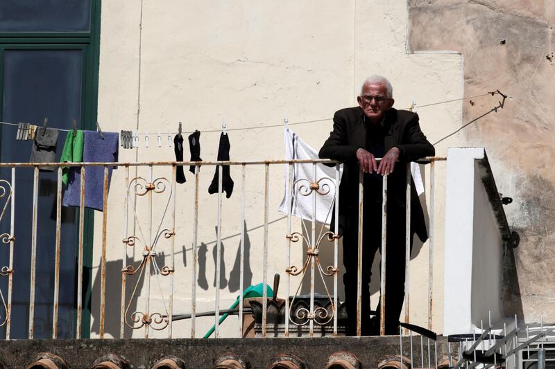  A man is seen on a balcony as Italy remains under a nationwide lockdown in a government decree that orders Italians to stay at home, in Amalfi, Italy, March 19, 2020. REUTERS/Ciro De Luca