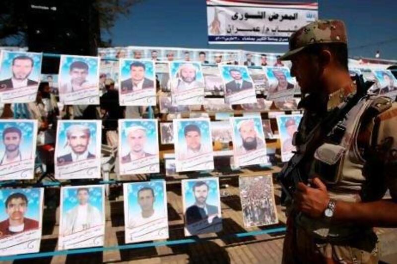 A Yemeni soldier passes posters of anti-government protesters who died last year during a rally against President Ali Abdullah Saleh.