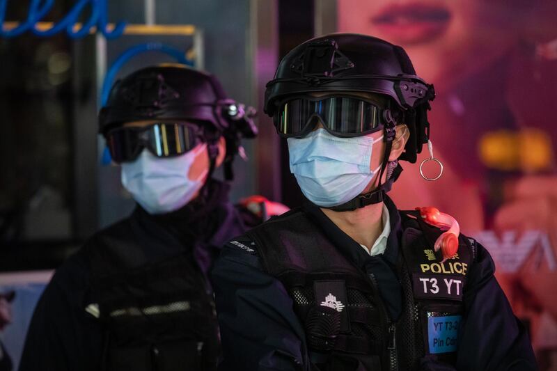 Riot police wear protective masks while standing guard on Nathan Street in the Mong Kok district of Hong Kong, China. Bloomberg