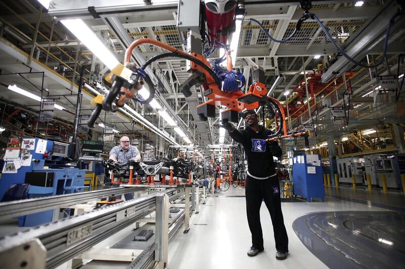 A worker handles a suspension for a 2014 Jeep Cherokee. Bill Pugliano / Getty Images / AFP