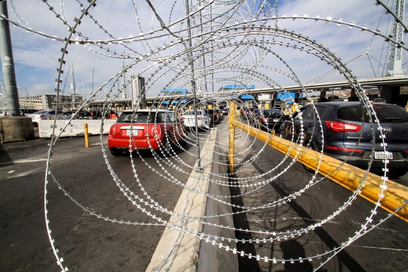 epa07178059 A view of a wire fence at the San Ysidro border checkpoint which connects San Diego and Tijuana, in Mexico, 19 November 2018. Thousands of migrants wait to demand asylum in the US as the border access has been closed for some hours in order to place 'reinforcement materials', which interrupted the crossing of vehicles and people temporarily.  EPA/Joebeth Terriquez