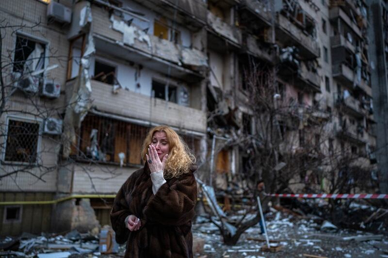 Natali Sevriukova stands next to her home after a rocket attack in Kiev, Ukraine. AP