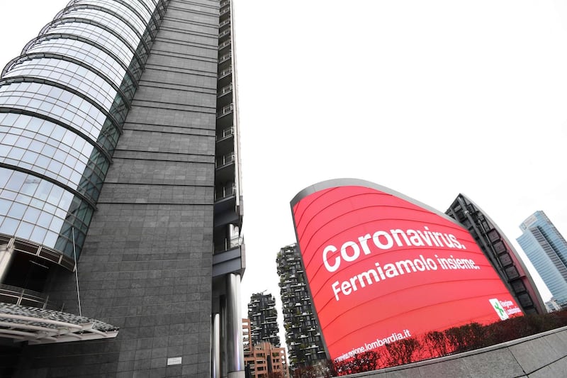 A poster reading "Coronavirus, let's stop it together" is pictured on Piazza Gae Aulenti in Milan. AFP