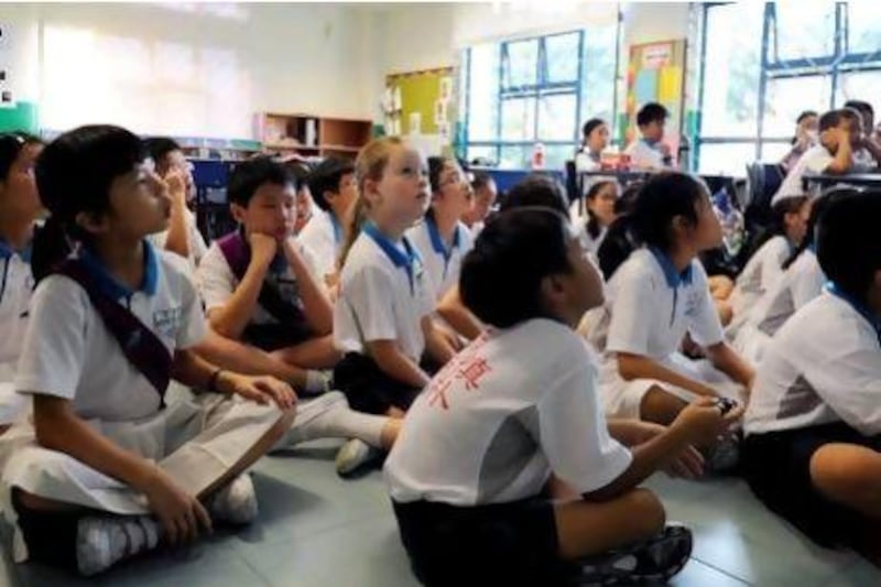 Happy Rogers, centre, the daughter of the billionaire US investor Jim Rogers, listens attentively to her Chinese teacher in her Mandarin class at Nanyang Primary School in Singapore. Mr Rogers believes young people the world over should prepare for the future by learning Mandarin. Simin Wang / AFP