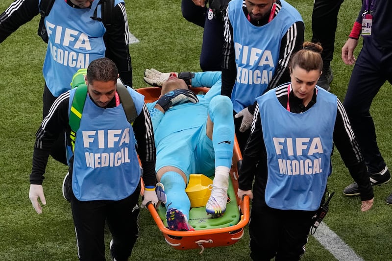 Medics carry Iran's goalkeeper Alireza Beiranvand from the pitch during the World Cup match against England on November 21. Photo: AP 