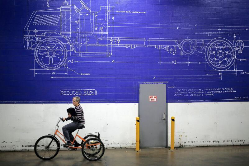An employee rides a bicycle past a mural at the Mack Truck Inc. cab and vehicle assembly plant in Macungie, Pennsylvania, U.S., on Thursday, Dec. 10, 2015. The U.S. Federal Reserve is scheduled to release industrial production figures on December 16. Photographer: Luke Sharrett/Bloomberg