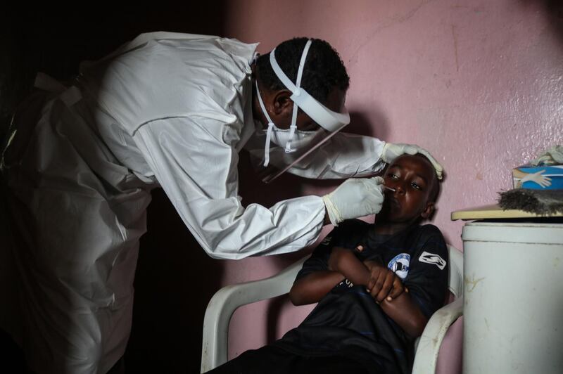 A staff member of the Ministry of Health takes samples from a boy during the first day of mass testing of the coronavirus in Djibouti. AFP