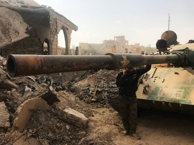 A member of the Syrian pro-government forces stands next to a tank in the eastern city of Deir Ezzor during an operation against Islamic State (IS) group jihadists on November 4, 2017.
The previous day, Russian-backed Syrian regime forces took full control of Deir Ezzor, which was the last city where IS still had a presence after being expelled from Hawija and Raqa last month. / AFP PHOTO / STRINGER