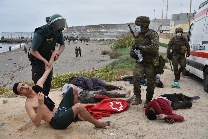 A Spanish Civil Guard holds onto a migrant who swam onto the Spanish enclave of Ceuta. AFP