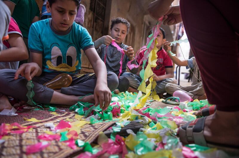 Children assist in the installation of Ramadan ornaments at the streets of Giza. EPA