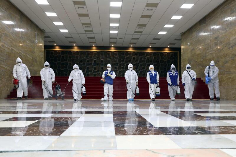 Workers from the South Korea Pest Control Association spray disinfectant as part of preventative measures against the spread of coronavirus at the National Assembly. AFP