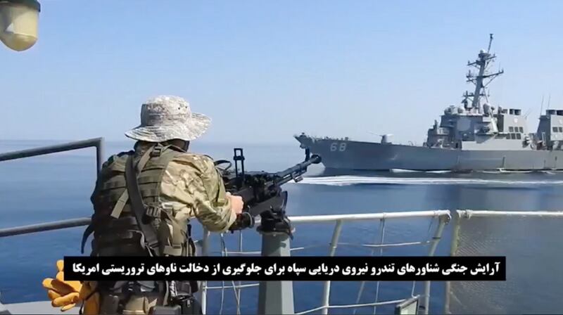 A video grab shows an Iranian soldier on a jet boat in front of a US warship during the seizure of a Vietnam-flagged oil tanker in the Sea of Oman. EPA