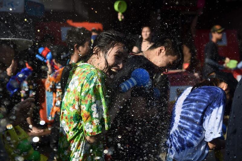 A woman reacts to being soaked in water during Songkran, or the Thai New Year, celebrations on Khaosan Road in Bangkok. Lillian Suwanrumpha / AFP