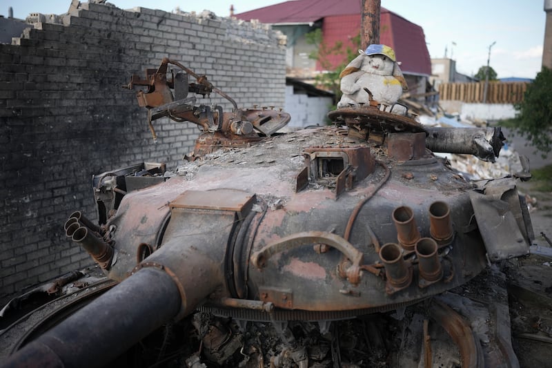 A cuddly toy adorns a destroyed Russian battle tank near damaged homes in Hostomel, Ukraine. Getty Images
