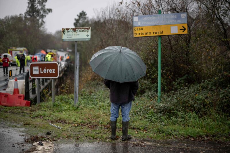 A resident looks on as emergency services work on a bridge above the Lerez river. AFP