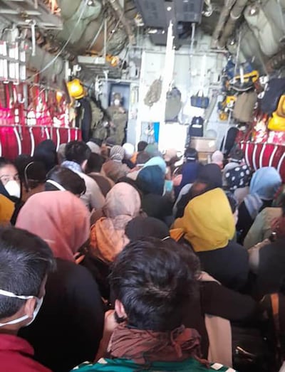 Members of the Afghanistan National Women's Football team and their families being evacuated from Kabul in the hold of a military cargo plane. Photo: Haley Carter