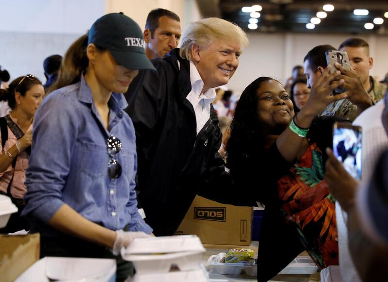 U.S. President Donald Trump poses for a photo as he and first lady Melania Trump help volunteers hand out meals during a visit with flood survivors of Hurricane Harvey at a relief center in Houston, Texas, U.S., September 2, 2017. REUTERS/Kevin Lamarque TPX IMAGES OF THE DAY