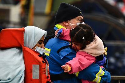 A coastguard carries a child at Dover marina. AFP