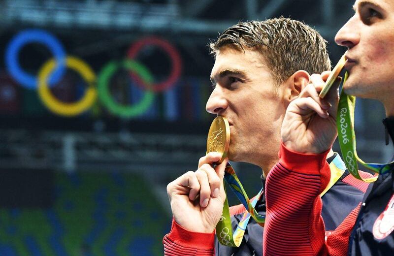 Michael Phelps of the USA poses with his gold medal after his team's victory in the men's 4x200m freestyle relay at the 2016 Rio Olympics. Bernd Thissen / EPA / August 9, 2016 