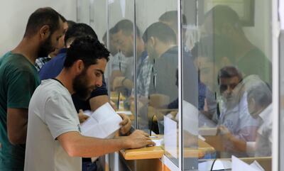 Palestinians receive their financial aid, 100 USD per needy family offered by Qatar, at a post office in Gaza City on June 27, 2020. / AFP / MAHMUD HAMS
