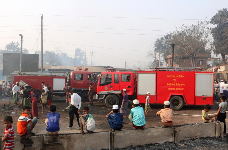 Rohingya refugees children watch fire engines at the site of Monday's fire at a Rohingya refugee camp in Balukhali, southern Bangladesh. AP Photo