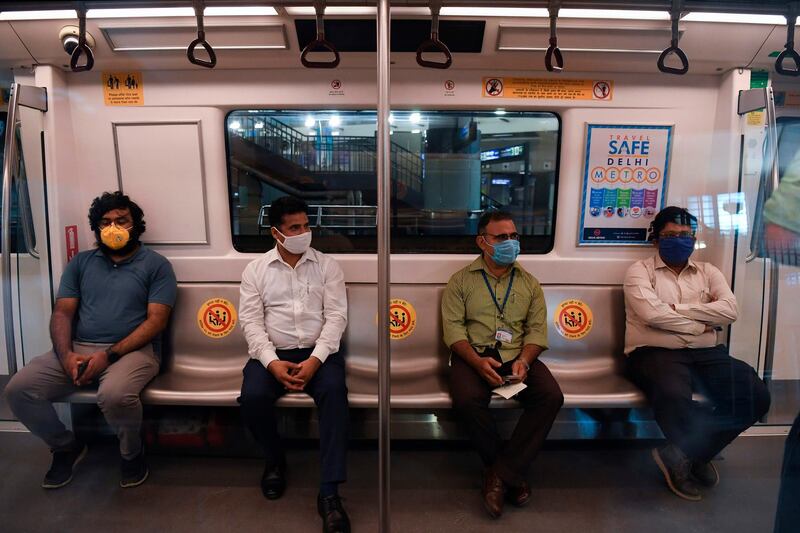 Delhi Metro employees sit inside a train during a media preview as the network prepares to resume services partially, at Rajeev Chowk metro station in New Delhi. AFP
