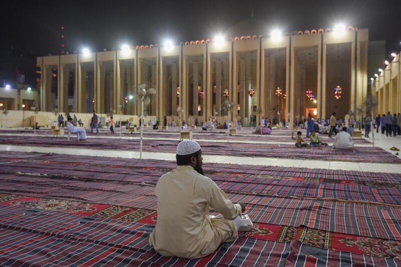 Worshippers sit outside of the Majidul Kabeer Grand Mosque in Kuwait City, Kuwait, on June 11, 2018. Noufal Ibrahim / EPA