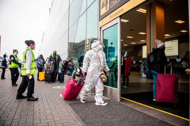 A passenger wearing a protective suit and face masks arrives at the Jorge Chavez International Airport in Callao, Peru, as international flights resume after more than six months due to the coronavirus pandemic. AFP