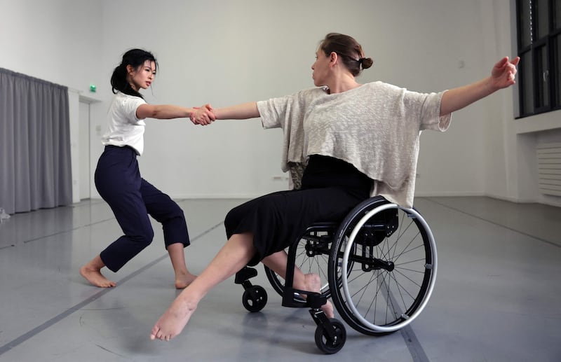 A dancer from the Paris Opera dances with a disabled dancer in her wheelchair during a rehearsal of the ballet "Passage" in Paris, on February 19, 2022. AFP