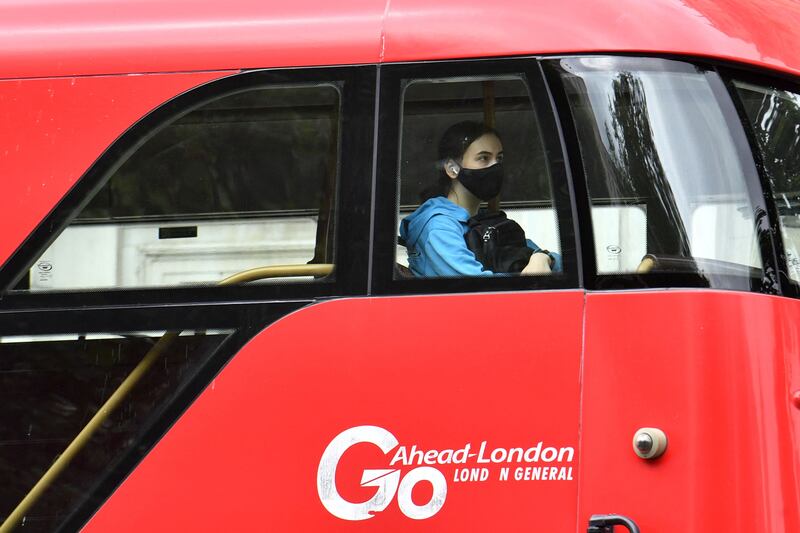 A passenger wears a face mask as she travels on a bus in central London.