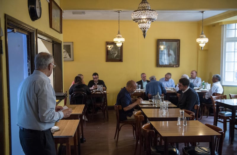 A staff member exits the kitchen as people eat lunch inside the India Club restaurant in London on October 16, 2017.
Plans to renovate a historic and beloved Indian restaurant in central London are causing a stir, pitting the developers against high profile defenders, including intellectuals, Anglo-Indian businessmen and lawmakers from both countries. / AFP PHOTO / CHRIS J RATCLIFFE / TO GO WITH AFP STORY BY JOE JACKSON