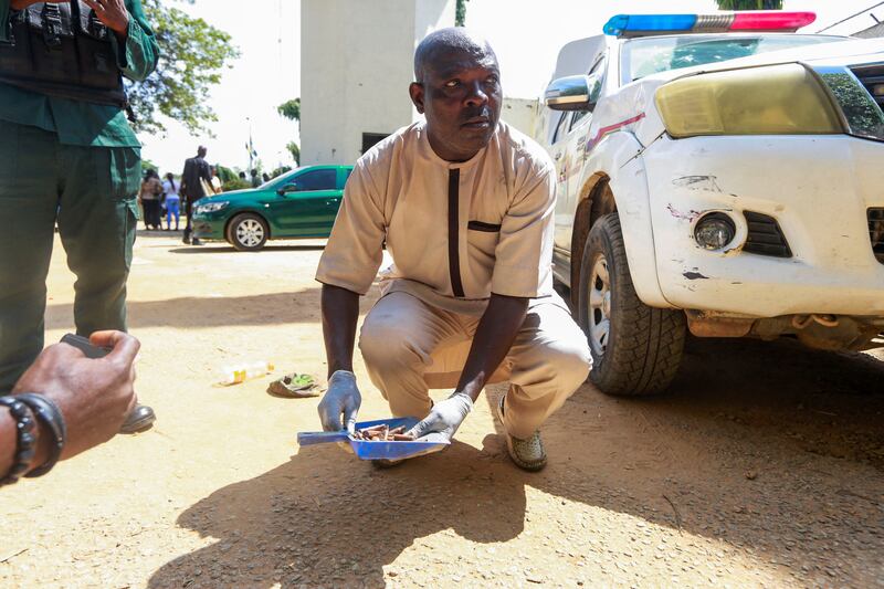 An explosive ordnance disposal officer picks up spent bullet casings at the prison in Kuje, after the raid. Reuters