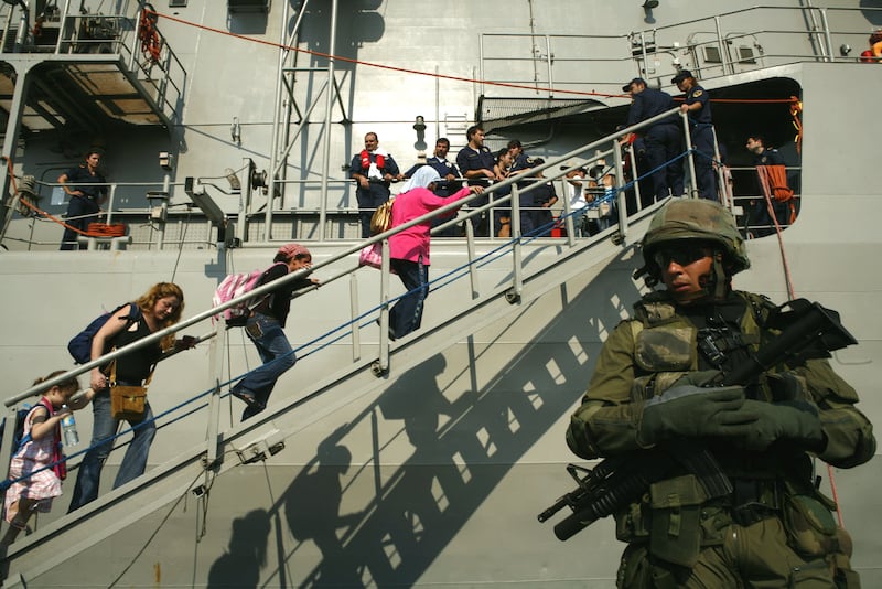 A Greek soldier stands guard as Greek citizens board the Greek frigate 'Psara' during an evacuation operation in Beirut port, July 18, 2006