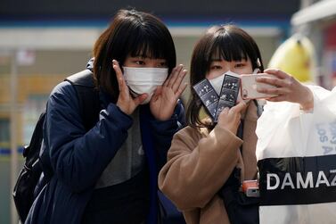 Tourists wearing masks to prevent the coronavirus take a selfie at a shopping district in Seoul, South Korea, February 24, 2020. REUTERS/Kim Hong-Ji