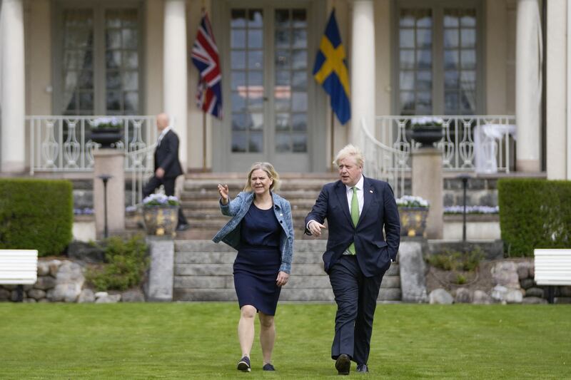 Mr Johnson and Ms Andersson take a walk around the gardens in Harpsund. AFP