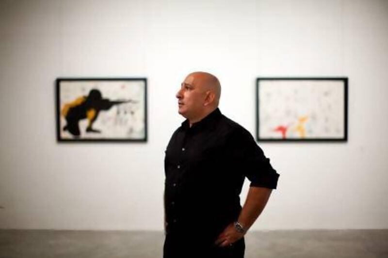 Khaled Hafez takes in his exhibition, which includes the painting Tomb Sonata in Three Military Movements. Christopher Pike / The National