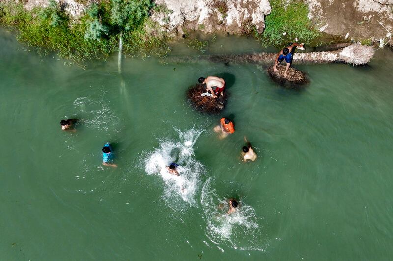 Youths in Al Indiyah, east of Karbala, cool off in the waters of Iraq's Euphrates river during a heatwave. AFP