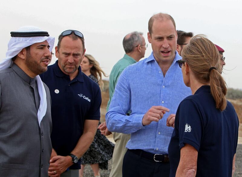 Britain's Duke of Cambridge Prince William (2nd R) and director of Kuwait's environment public authority Sheikh Abdullah Ahmad Al-Humoud Al-Sabah (L) talk to the staff at Jahra Pools nature reserve, 35kms north of the Kuwaiti capital, during a beach cleaning operation. AFP