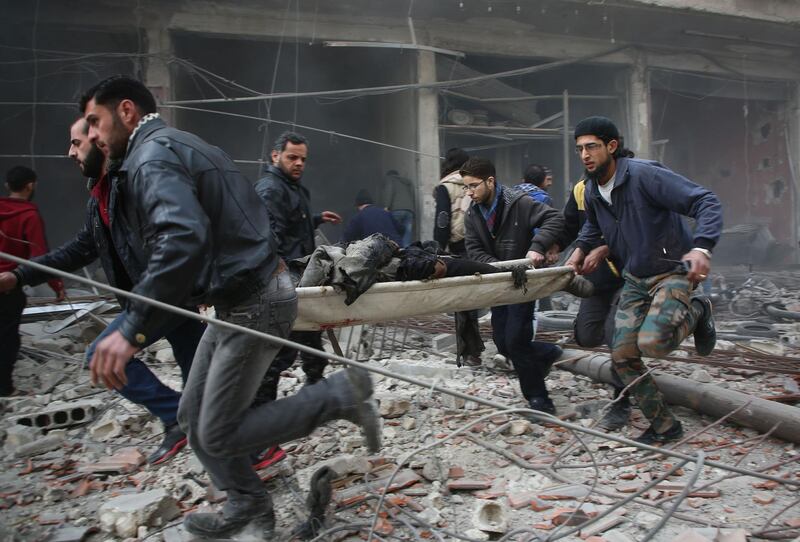 TOPSHOT - EDITORS NOTE: Graphic content / Syrian rescuers evacuate badly injured people following regime strikes on the besieged rebel-held enclave of Kafr Batna near Damascus on February 6, 2018 in which 35 civilians were killed. 
The bloodshed came a day after another 31 civilians were killed in Eastern Ghouta and as the United Nations pleaded for a truce in the seven-year-old conflict to allow for aid deliveries.

 / AFP PHOTO / Amer ALMOHIBANY