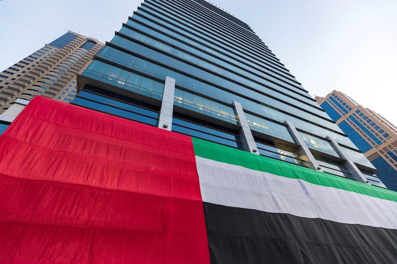 Dubai, United Arab Emirates - November 27, 2018: A giant flag is displayed on a skyscraper in JLT for National day. Tuesday the 27th of November 2018 in JLT, Dubai. Chris Whiteoak / The National