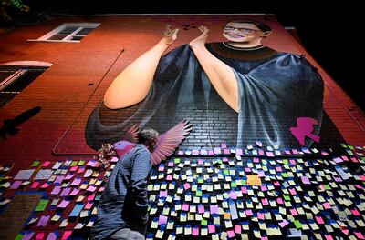 TOPSHOT - Andrew Oros looks at messages of thanks and gratitude taped on a mural memorial to late Supreme Court Justice Ruth Bader Ginsburg in downtown Washington, DC  on September 23, 2020. Ginsburg, whose death has opened a crucial Supreme Court seat that Republican President Donald Trump has promised to quickly and controversially fill against the wishes of Democrats, will lie in repose beginning September 23, 2020 at the US high court. Trump will announce his pick to replace Ginsburg Saturday, with Senate Republicans promising a swift vote on the nominee.
 / AFP / ANDREW CABALLERO-REYNOLDS
