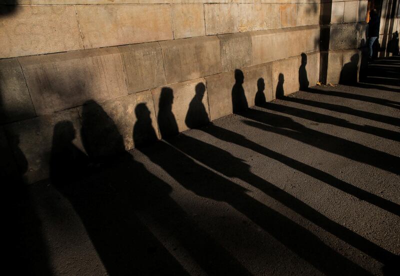 The shadows of voters wait in line to cast their ballot in Catalonia's regional elections in Barcelona, Spain. Jon Nazca / Reuters